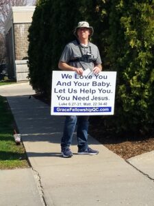 Allen manning a sign outside Planned Parenthood in Iowa City